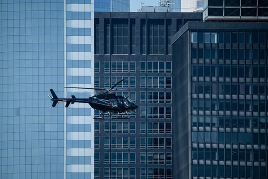 Helicopter among glass high rise buildings
