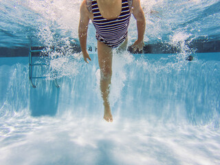 Faceless irl in striped swimsuit jumping into public pool