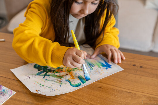 Artistic Focus. Girl Creates Masterpiece with Watercolors and Brush.