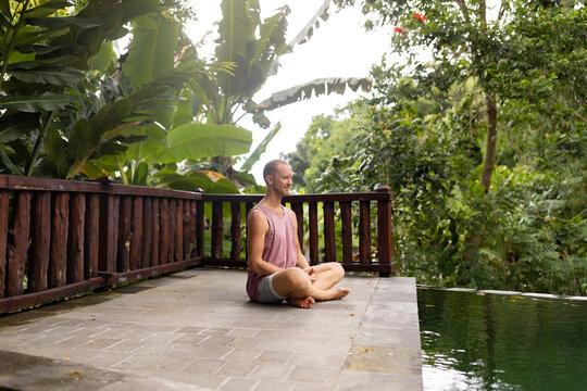 Adult male meditating outdoors in the tropical garden