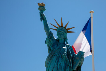 Statue of Liberty with French tricolors blue white red flag fluttering waving front on mat and blue...