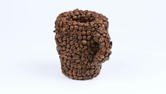 A cup made of coffee beans on white. Side view. Loop motion. Rotation 360. 4K UHD video footage 3840X2160.