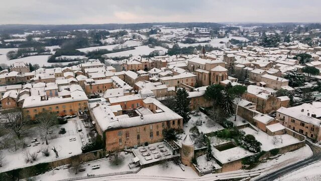 Aerial view of Monpazier church in the snowy morning, streets empty, market square visible, Dordogne, France