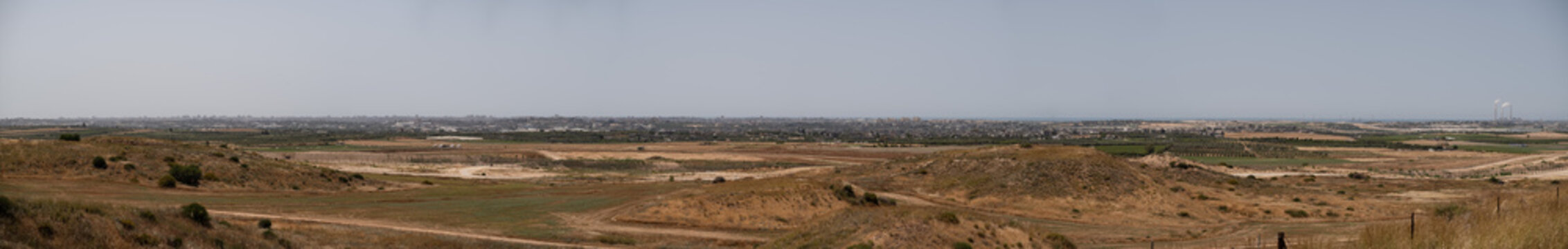 Panoramic view of the Gaza Strip, as seen from Assaf Siboni overlook in southern Israel. High-rises, farmlands, and other features of the Gaza Strip are visible.