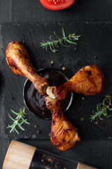 Grilled chicken wings with rosemary and spices and barbecue sauce. on a black background