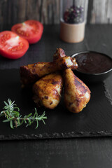 Grilled chicken wings with rosemary and spices and barbecue sauce. on a black background