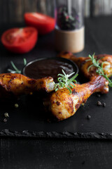 Grilled chicken wings with rosemary and spices and barbecue sauce. on a black background