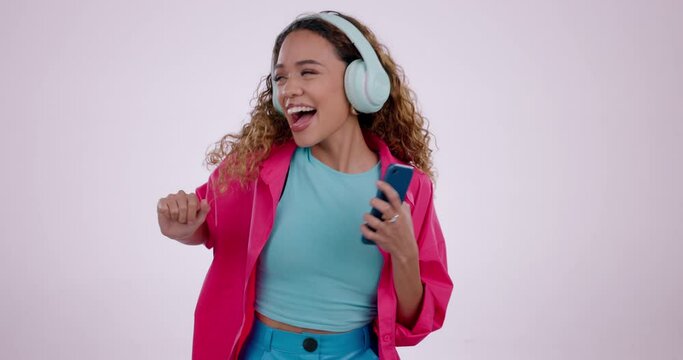 Face of woman, headphones and dancing in studio to celebrate freedom, party and audio multimedia on white background. Portrait of happy model listening to music, dance with energy and sound on radio