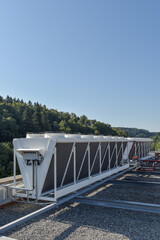 double stack dry cooler on a roof next to a forest with blue sky - hot or cool fluid and air exchange system