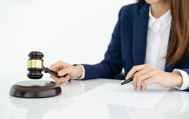 Close-up image, A professional female lawyer with a judge gavel or judge hammer on the desk. Selective focus on judge gavel. Law and Legal concept.