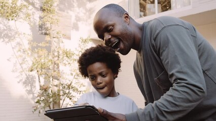 close up Black father and son discussing how big the renovation will be on digital tablet in garden at home