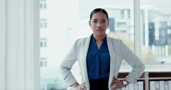 Face, mission and a confident business woman in the office with an ambition for growth or success. Portrait, corporate and a serious young employee hands on hips in her professional workplace