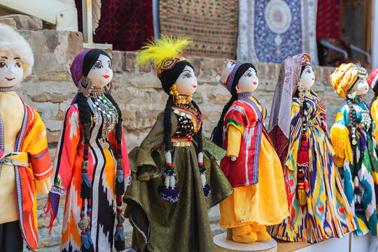 Dolls dressed in traditional uzbek costumes. Traditional souvenir puppet from painted mashed paper (papier mache). Close up, selected focus. Bukhara (Buxoro), Uzbekistan. Souvenir and gift concept
