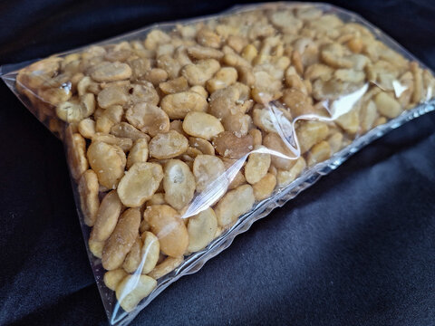 Selective focus. View of tasty koro bean or nut as healthy snack. Koro bean in transparant plastic packing.