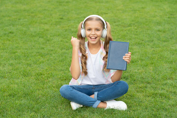 happy teen girl in music headphones. education through self reading book. audio book or ebook. teen girl lifestyle. relax in park. music education while listening. lifestyle of girl outdoor