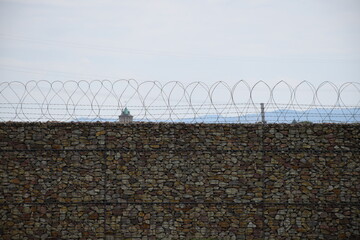 Natursteinmauer mit Stacheldraht