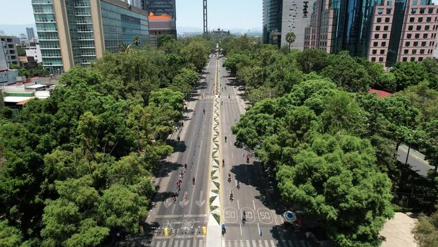 ascending drone shot of sunday cycling on paseo de la reforma in mexico city in front of chapultepec castle