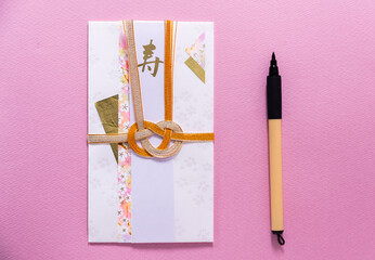 明るいピンク色の背景紙と水引きが美しい祝儀袋