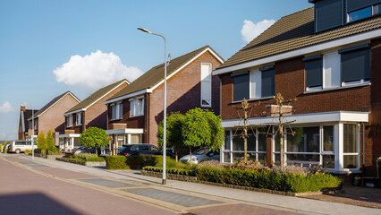 Dutch Suburban area with modern family houses, newly built modern family homes in the Netherlands, family houses in the Netherlands, Row of modern houses in a family friendly suburban neighborhood  - obrazy, fototapety, plakaty