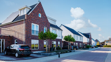 Dutch Suburban area with modern family houses, newly built modern family homes in the Netherlands, family house in the Netherlands, newly built houses in a family friendly modern suburban neighborhood - obrazy, fototapety, plakaty