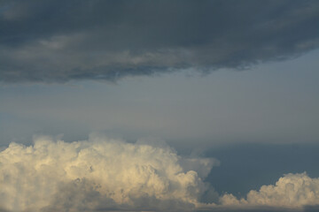 White fluffy clouds and black clouds meet in the sky