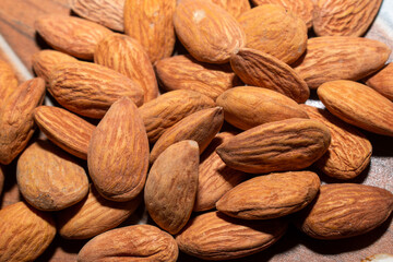 Almonds on brown wooden background