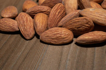 Almonds on brown wooden background