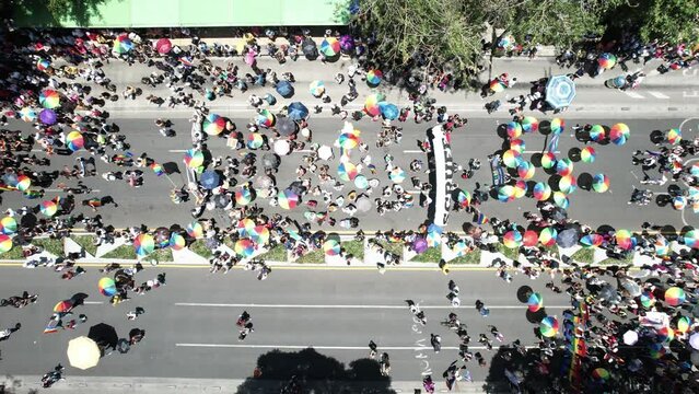 overhead drone shot various umbrellas with the colors of the gay pride in the pride march of mexico city 2023