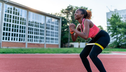 The black woman incorporates resistance bands into her training routine, leveraging their...