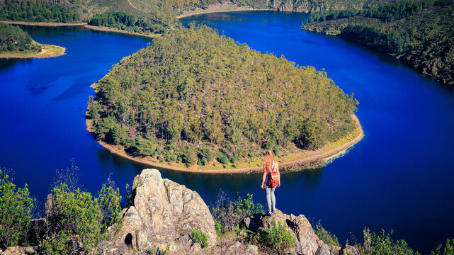 Woman standing on peak enjoying view of meander- Adventure, explore, wanderlust travel concept