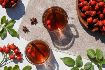 Glass cups with decoction of freshly prepared tea with rose hips on a marble table. Vitamin useful...