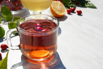 Rose hip tea with lemon,honey mint, products containing vitamin C. Healthy ingredient. Alternative medicine and herbal therapy concept. Side view, copy space for text.

