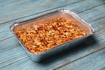 Baked hot sushi rolls in baking dish on a blue wooden background