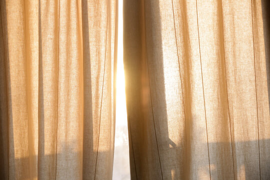Sunlight breaking through curtains, summertime, golden hour time	