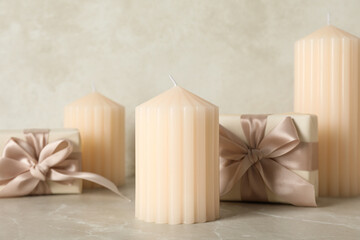 Candles and gift boxes on beige background