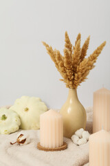 Candles, bouquet and zucchini on light background
