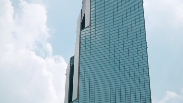 Coex WTC Trade Tower Glassy Building Against Cloudy Sky, Seoul, South Korea. Low angle tilt up.