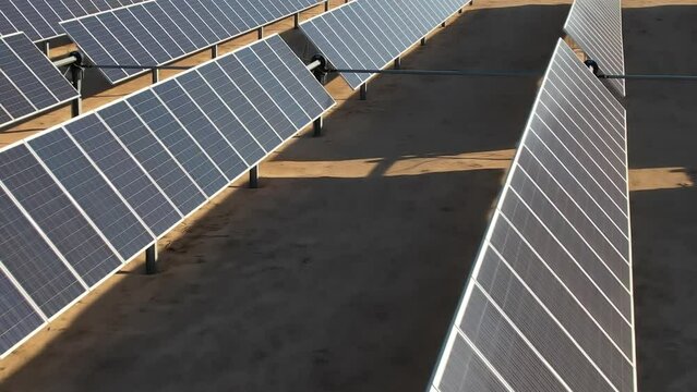 Aerial over up close solar panels, photovoltaic farm of energy powered by the sun