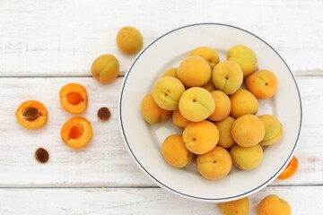 Naklejka na ściany i meble Apricots, still life, fresh fruits, on a white wooden table, top view, place for text, free space, background