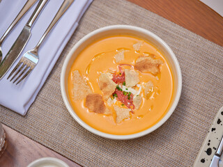 Bowl of orange soup puree in plate