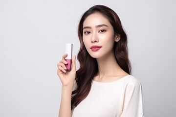 model in a white studio backdrop, holding a lipstick. Showcase the vibrant colors of the lipstick, contrasting with the clean,Generated with AI