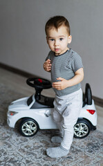 A young boy posing with a toy car