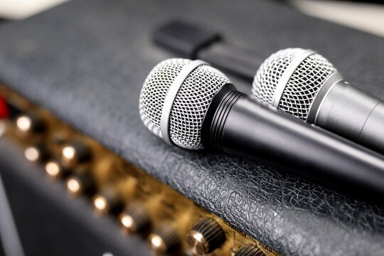 Two wireless microphones on a black guitar amplifier, amp, closeup. 