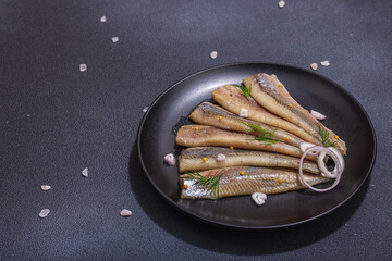 Fillet of pickled marinated sea herring fish with shallots and dill. Served ready to eat seafood