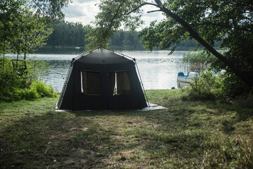 Namiot rozłożony nad brzegiem jeziora w słoneczny dzień. - obrazy, fototapety, plakaty