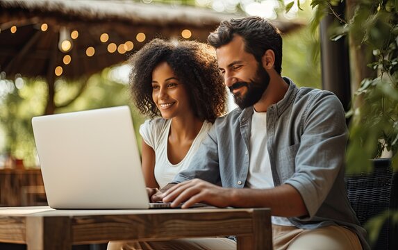 Pleasant family couple sitting looking at laptop screen. Happy young spouse web surfing, making purchases online or booking flight tickets. Created with Generative AI technology.