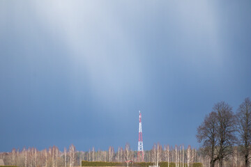 a red and white cell phone tower in a park.