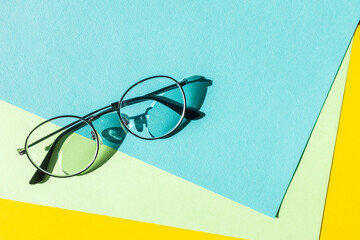 Business black glasses on blue, yellow, green background. Fashion office glasses reading in summer concept for promo banner sale and shopping