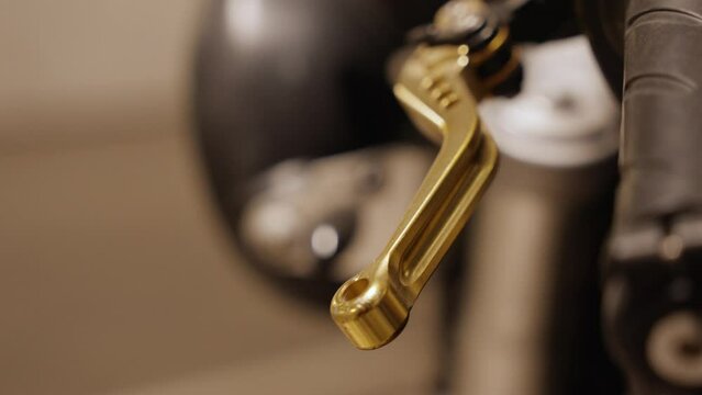 Motorcycle handlebar with a golden gearshift.