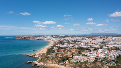 Fototapeta na wymiar Aerial photo of the beautiful town in Albufeira in Portugal showing the Praia da Oura golden sandy beach, with hotels and apartment in the town, taken on a summers day in the summer time.